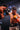 Two boxers in a match, one wearing orange gloves and the other in black gloves.